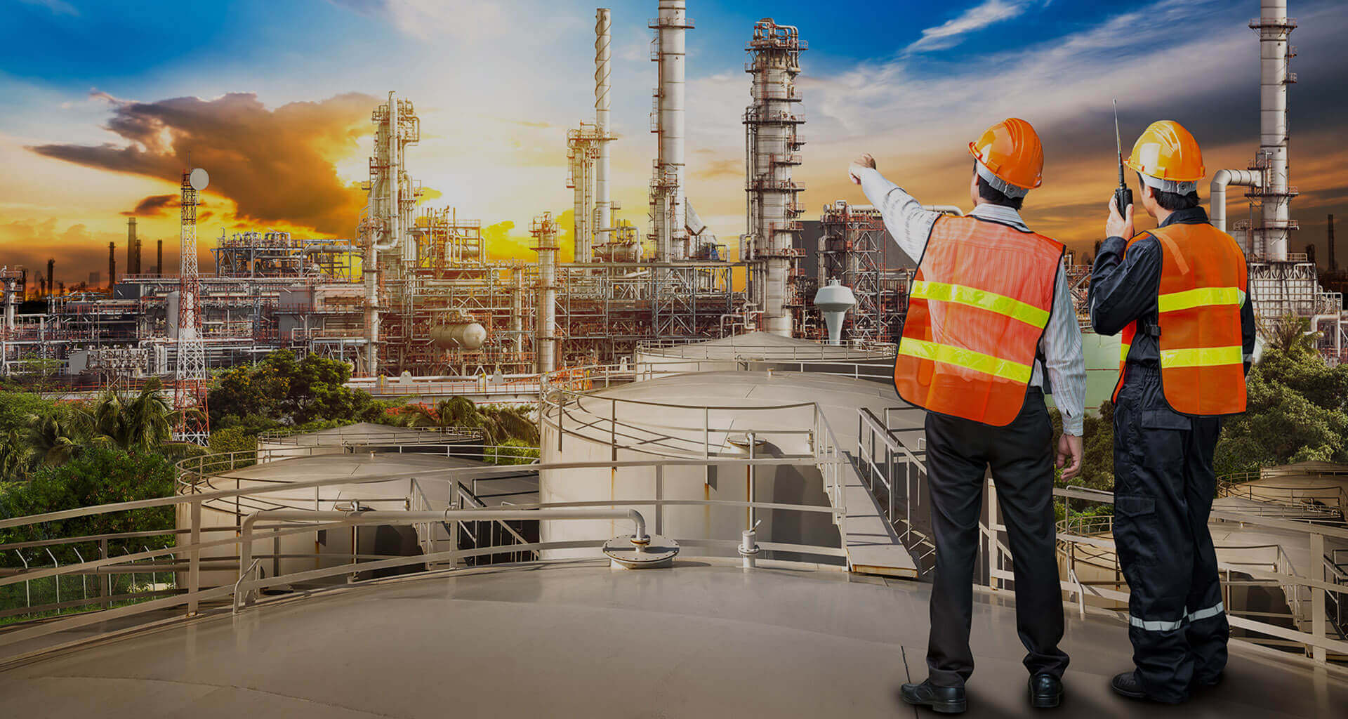 Engineers in safety gear operating machinery in an industrial plant